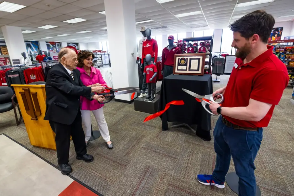Chancellor Susan Elrod, Jerry Hammes, and store manager Steven Turnbull had the honor of cutting the ribbon at the grand opening of the new campus store.